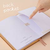 Hand opening the expandable back pocket of the tsuki kuma bullet journal