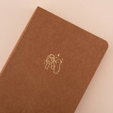 Close up of tsuki kuma brown velvet bullet journal with a bear design in gold foil