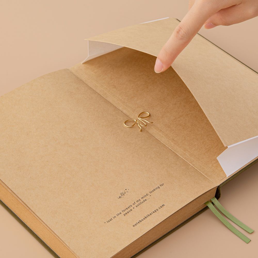 Kraft paper notebook and a hand opening the expandable back pocket