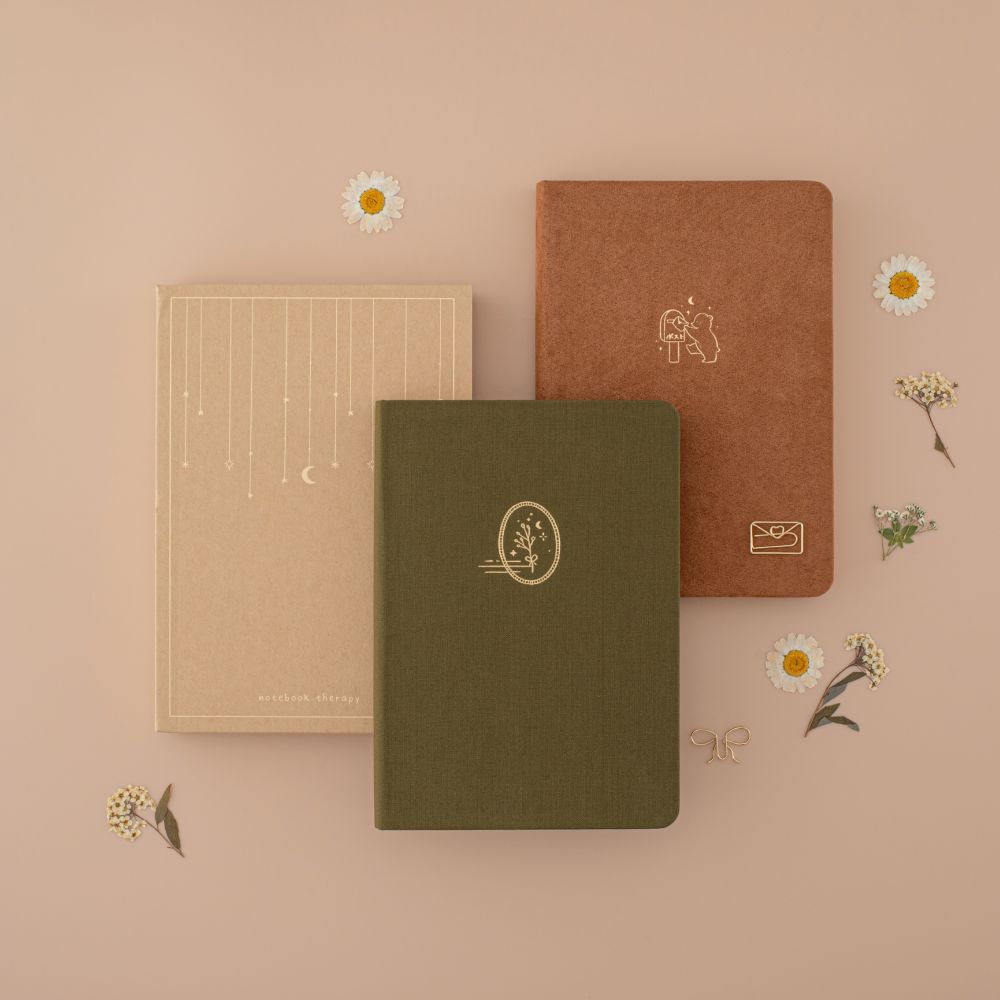 Kraft paper recyclable gift box with green linen and brown velvet notebook flatlay with dried flowers around them