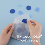 Hand holding wax seal sticker set and taking out one dark blue wax seal stamp sticker
