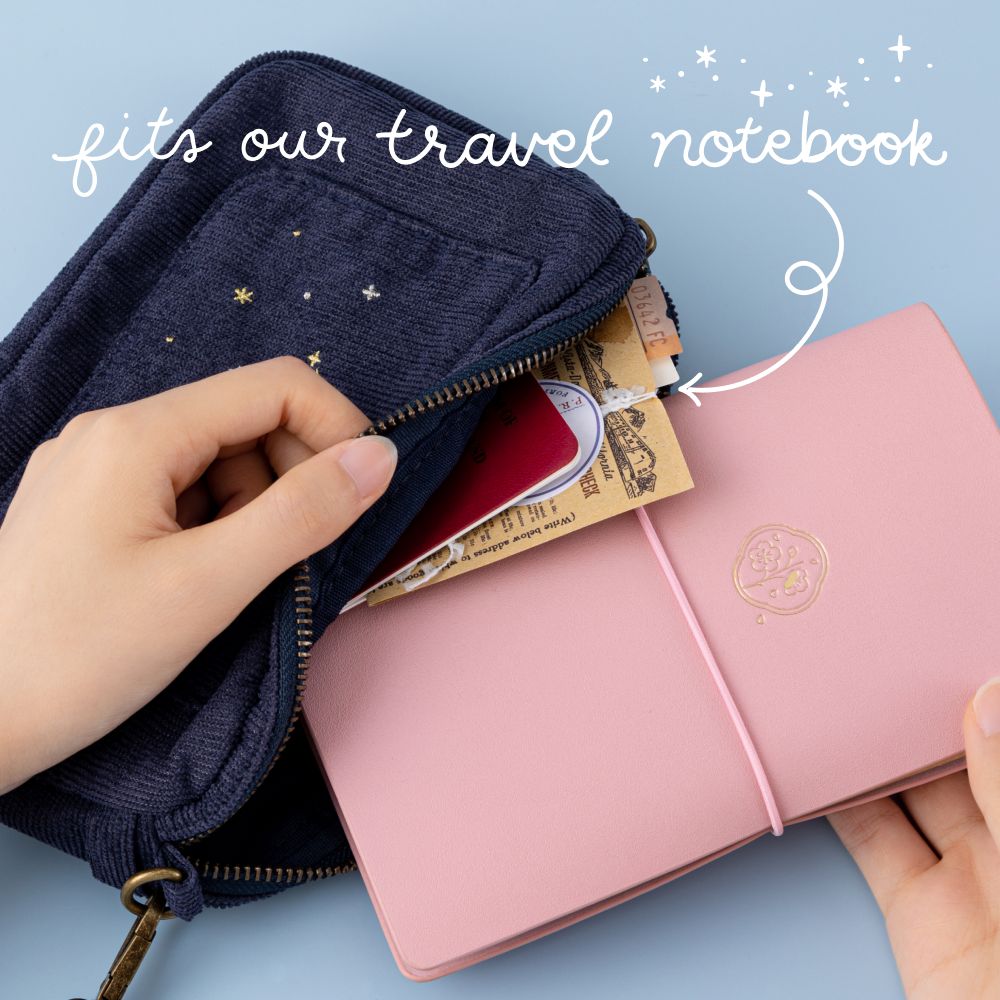 Tsuki ‘Cloud Dreamland’ Travel Pouch which fits all your travel essentials and Tsuki ‘Sakura Journey’ Limited Edition Travel Journal held in hands in blue background