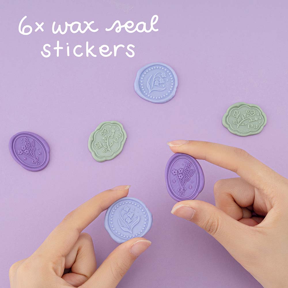 6x wax seal sticker with lavender and bluebell designs, hand-holding 2 different wax seal stickers on purple background