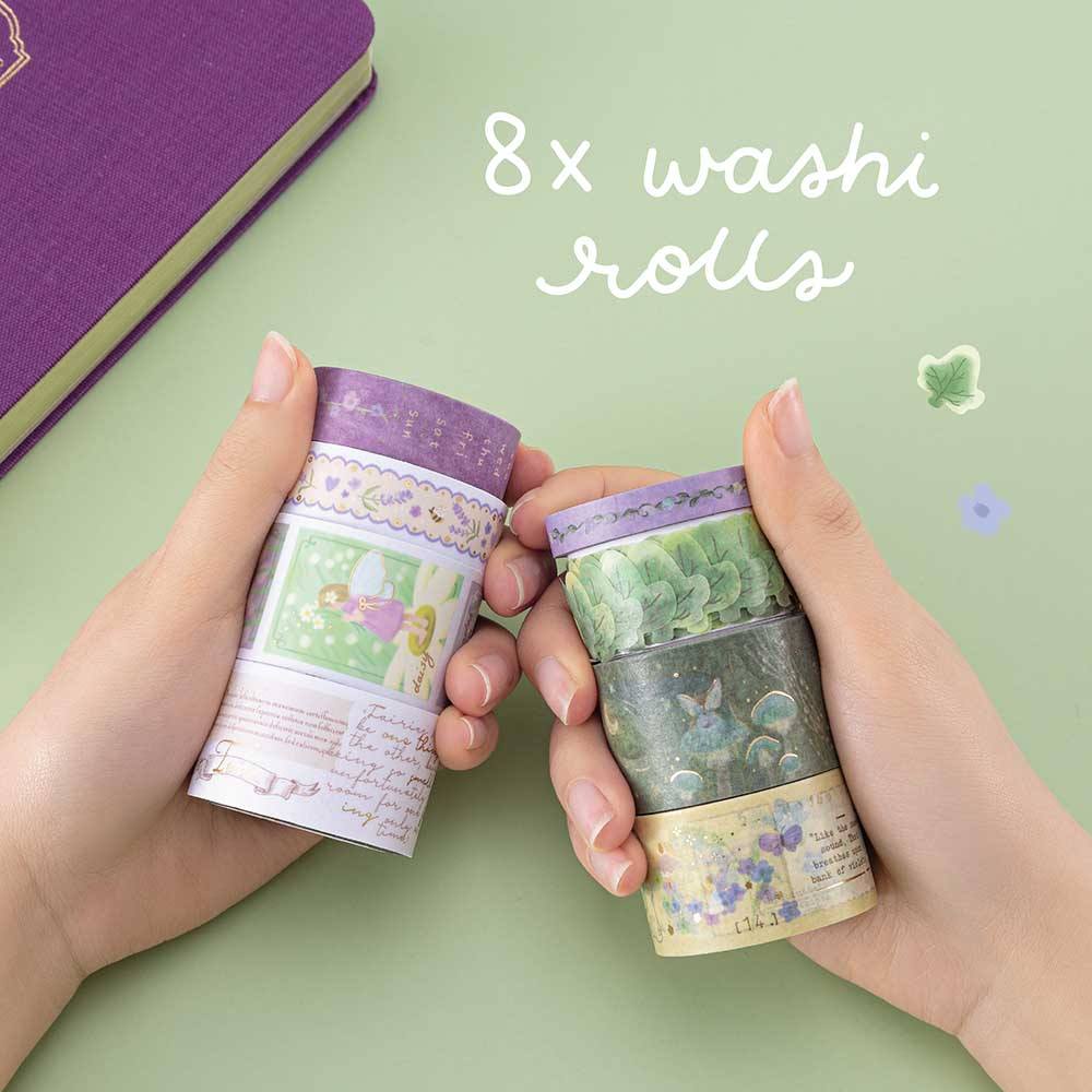 Hands holding Tsuki ‘Enchanted Garden’ Washi Tape Set on sage green background with purple flower decoration