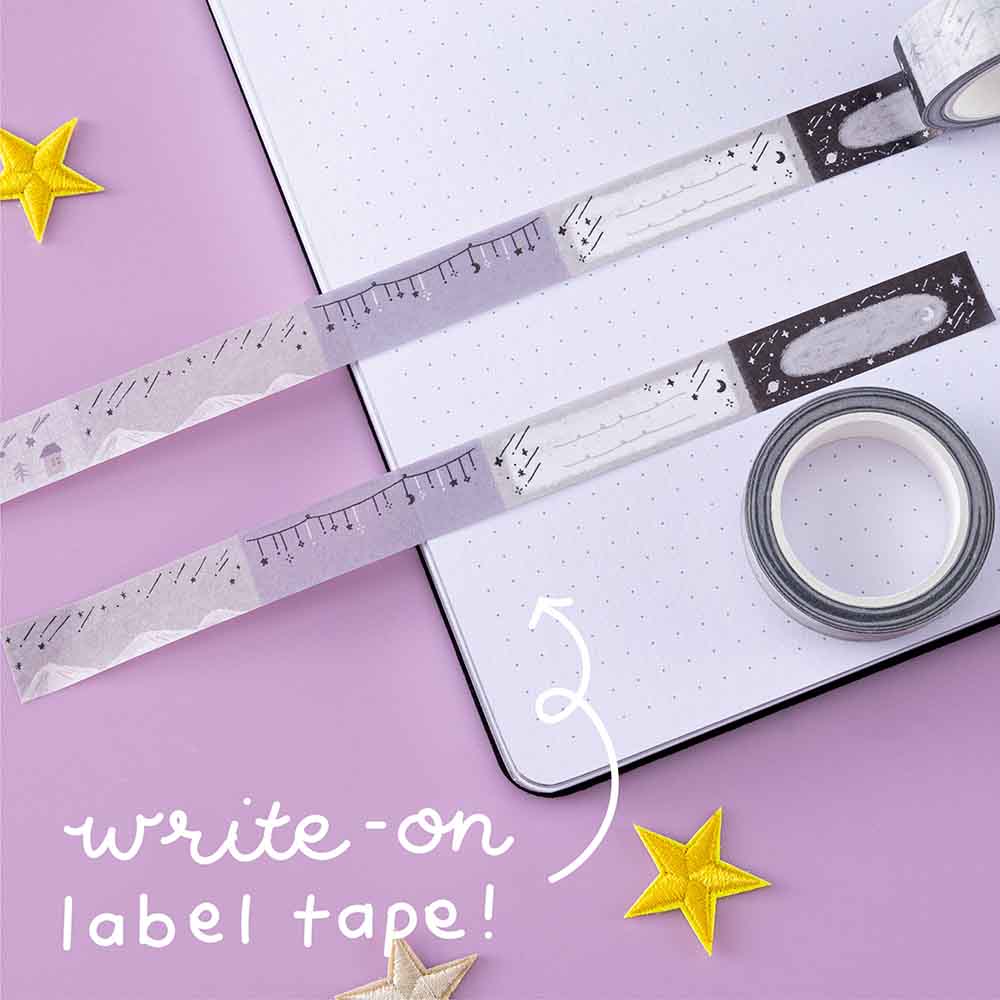 Write on label tape from Tsuki ‘Falling Star’ Washi Tape Set rolled out on open bullet journal page with stars on purple background