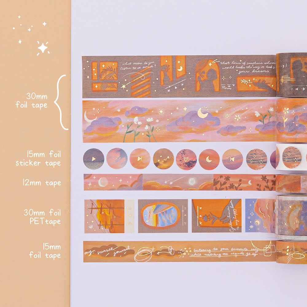 Swatch of Tsuki Golden Hour washi tapes on white paper on top of orange background. Washi tapes include 2x 30mm foil tape, 15mm foil sticker tape, 12mm tape, 30mm foil PET tape and 15mm foil tape