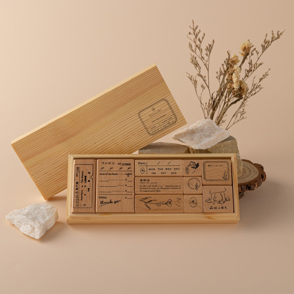 Opened wooden box of stamps on beige background with dried flower decoration