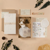 Opened box of scrapbook set flatlay with leaves on the side