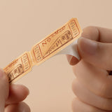 Close up of train ticket sticker showing a hand removing adhesive backing