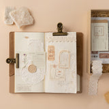 Scrapbook set items including lace, doilies and memo pad stuck on the travel notebook
