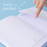 Finger lifting up the back pocket of a bullet journal