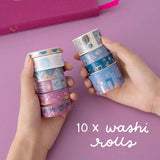 Hands holding 10x washi tape rolls on pink background
