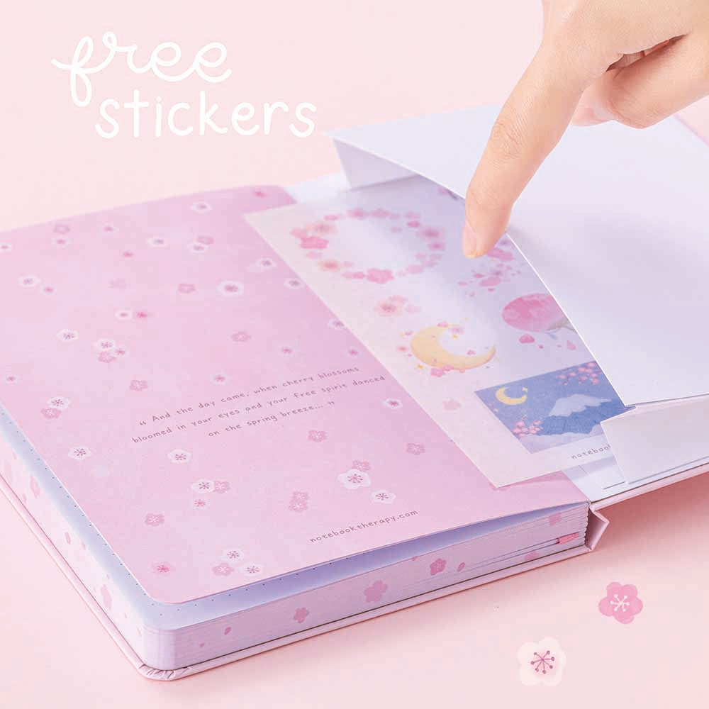 Open back page pocket of Tsuki Four Seasons: Spring Collector’s Edition 2022 Bullet Journal held in hands in light pink background