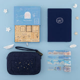 Flatlay of Dream Sailing notebook, Cloud Dreamland stamps, travel pouch and washi tapes