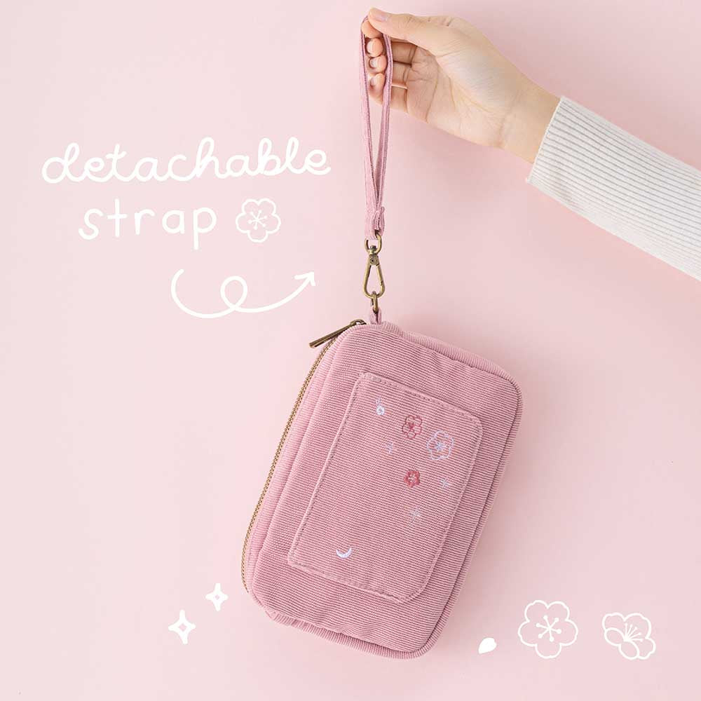Tsuki ‘Sakura Journey’ Travel Pouch held in hands by detachable strap in pink background