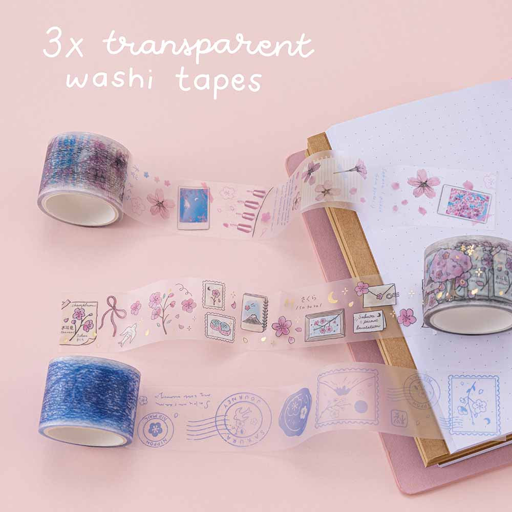 Close up of three Tsuki ‘Sakura Journey’ Vintage Journal Washi Tapes with Tsuki ‘Sakura Journey’ Limited Edition Travel Notebook on pink background