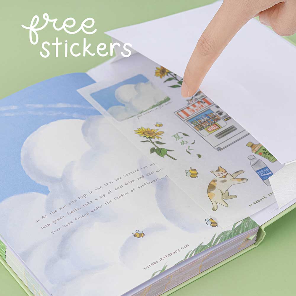 Hand opening the back pocket of Tsuki Four Seasons Summer Collectors Edition 2022 sage bullet journal notebook and revealing a sticker sheet with the text “free stickers” handwritten in white