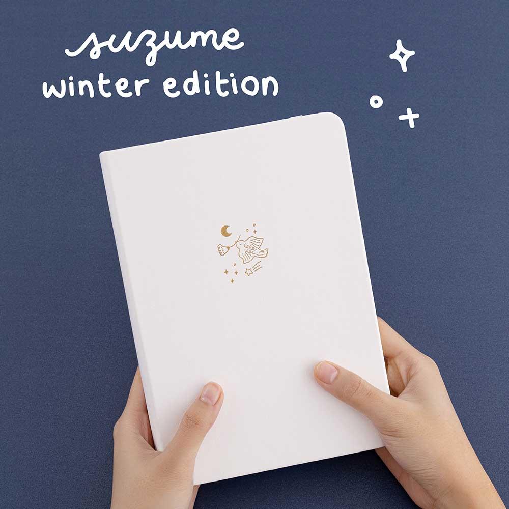 Tsuki ‘Suzume’ Winter Limited Edition Bullet Journal held in hands in navy background