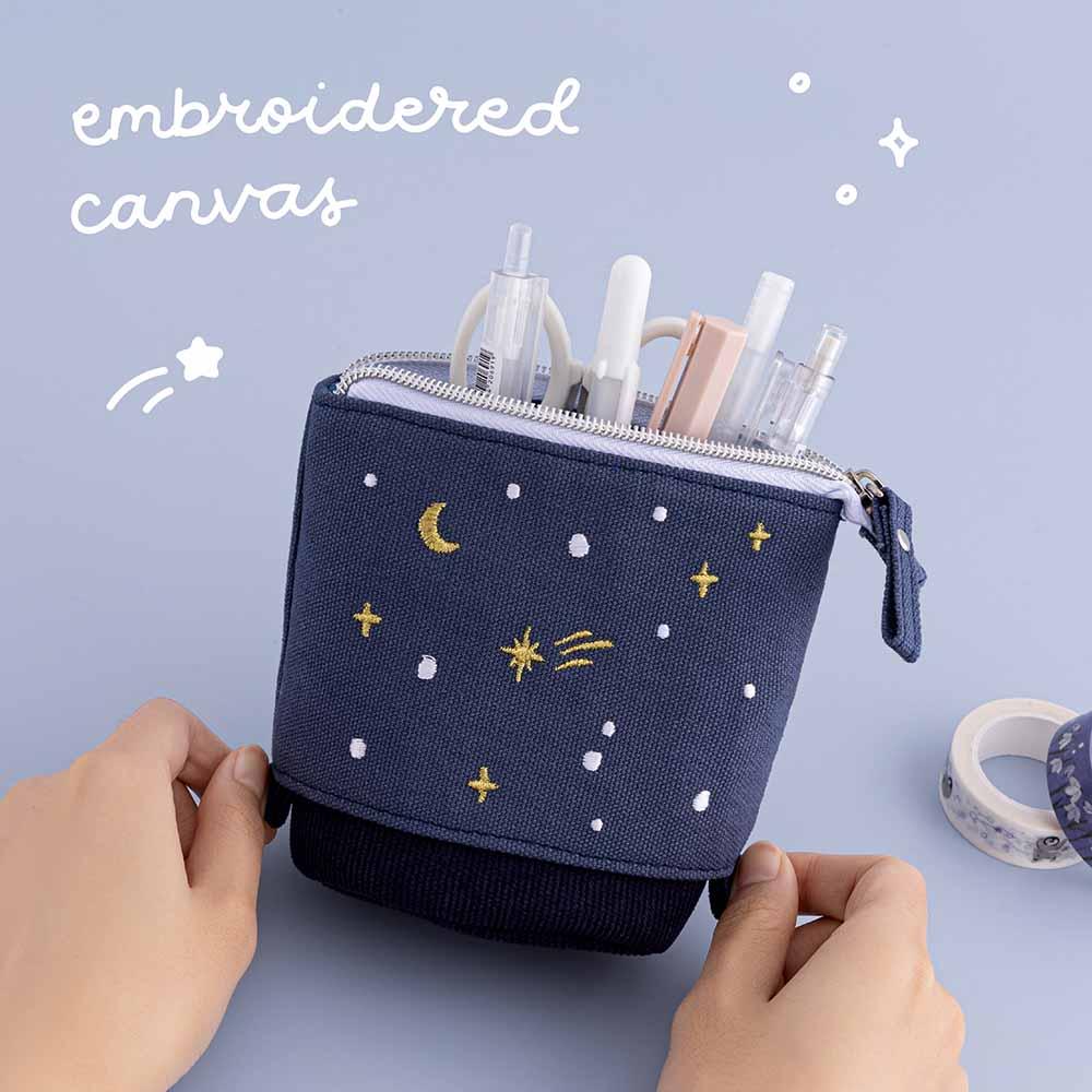 Tsuki ‘Dreams of Snow’ Pop-Up Pencil Case in Starry Night in embroidered canvas held in hands over Tsuki ‘Dreams of Snow’ Holographic Washi Tapes in light blue background