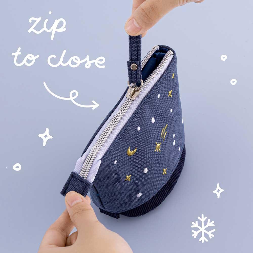 Tsuki ‘Dreams of Snow’ Pop-Up Pencil Case in Starry Night with zip to close held in hands in light blue background