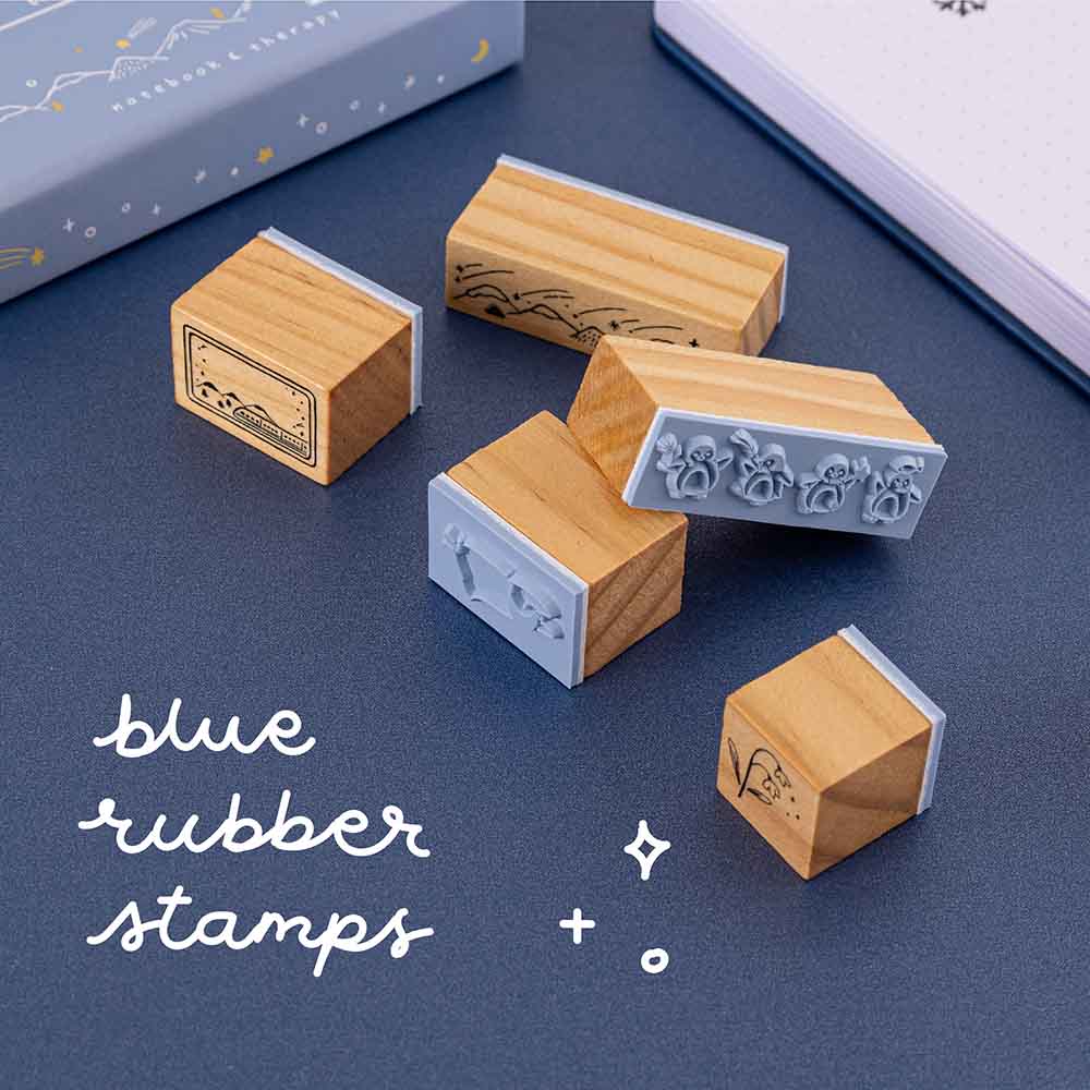Close up of blue rubber stamps from Tsuki ‘Dreams of Snow’ Bullet Journal Stamp Set on navy background
