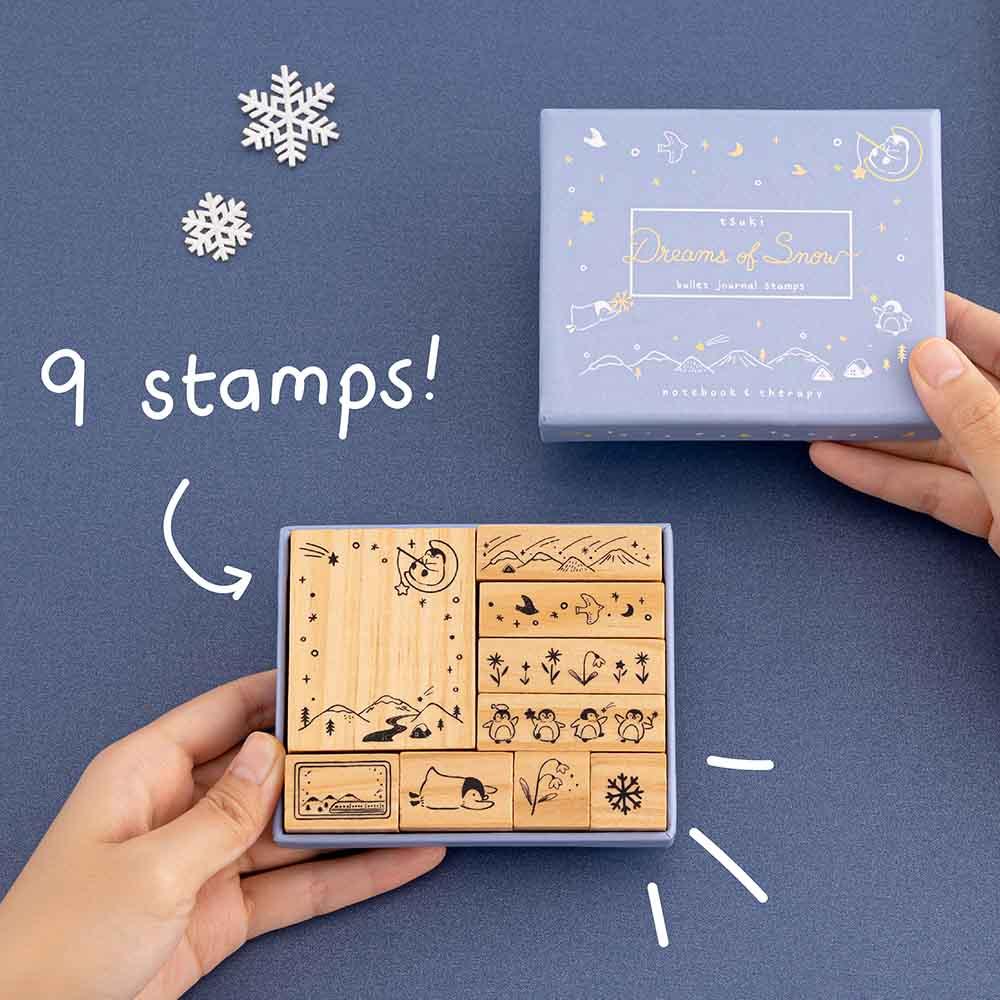 Tsuki ‘Dreams of Snow’ Bullet Journal Stamp Set with nine stamps held in hands in navy background